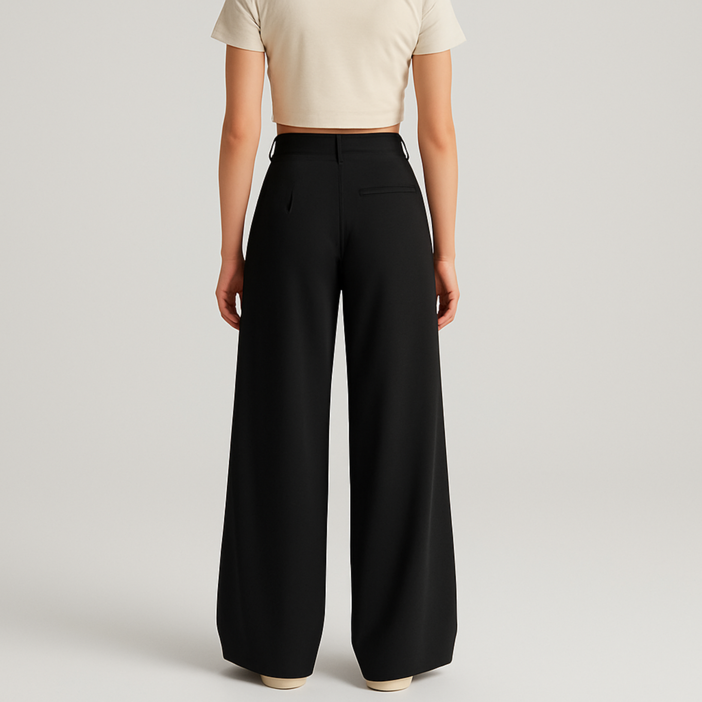 BACK IMAGE OF FEMALE MODEL WEARING BLACK LOOSE KOREAN TROUSER WITH VERY EXTRA WIDE LEGS WITH SINGLE CUTPOCKET AT RIGHT BACK. BELT LOOPS AT WAIST. MODEL IS WEARING CREAM CROP T- SHIRT AND CREAM SHOES.