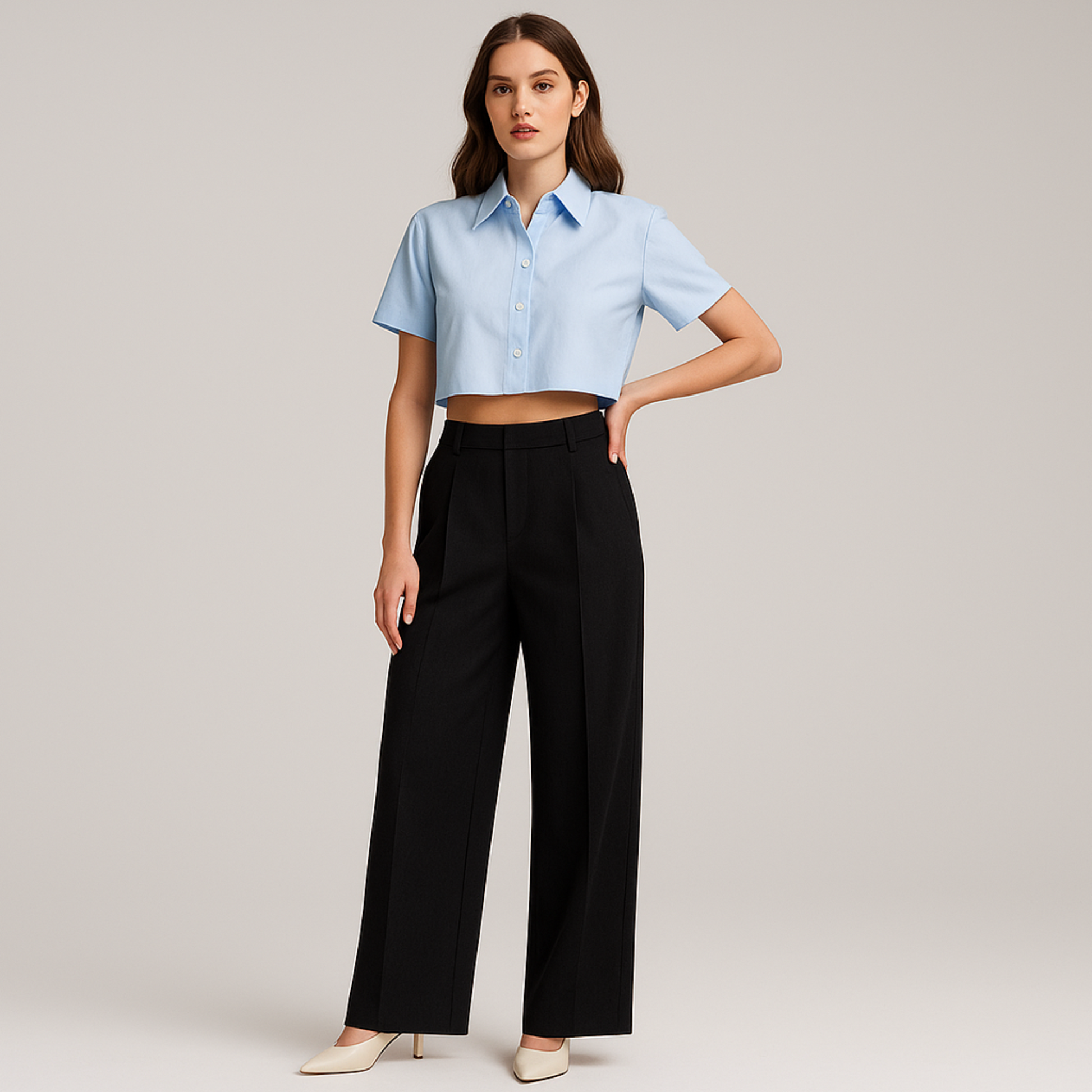 FEMALE MODEL WEARING BLACK TROUSER WITHOUT ANY PLEATS. PREMIUM LOOKING FABRIC. LOOSE STRAIGHT FROM HIPS  AND EXTRA WIDE LEGS. TROUSER HAVE CROSS POCKETS AT FRONT ,BELT LOOPS . MODEL IS POSING WITH ONE HAND ON WAIST AND OTHER HAND STRAIGHT. WEARING LIGHT SKY BLUE COLLARED CROP FULL SHIRT WITH CREAM HIGH HEELS