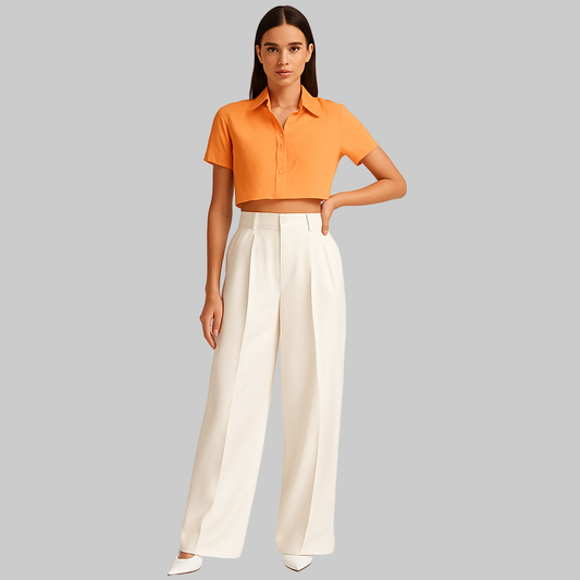 FEMALE MODEL WEARING  WHITE  DOUBLE PLEATED LOOSE STRAIGHT FROM HIPS  AND EXTRA WIDE LEGS. TROUSER HAVE CROSS POCKETS AT FRONT ,BELT LOOPS . MODEL IS POSING WITH ONE HAND ON WAIST AND OTHER HAND STRAIGHT. MODEL IS WEARING WHITE HEELS WITH LIGHT ORANGE CROP SHIRT