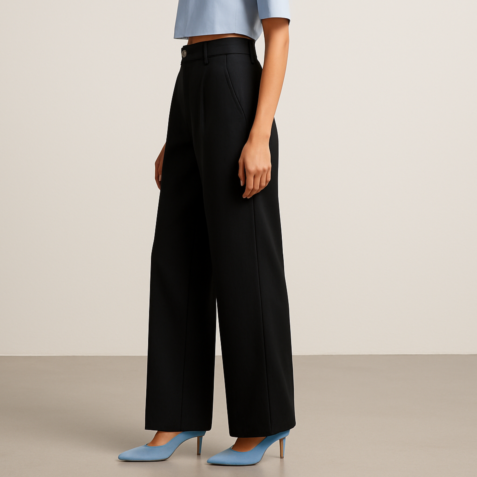 SIDE IMAGE OF FEMALE MODEL WEARING BLACK TROUSER. STRAIGHT LOOSE  FROM HIP TO BOTTOM WITH EXTRA  WIDE LEGS. CROSS POCKET AT SIDE ,BELT LOOPS. MODEL IS WEARING LIGHT SKY BLUE HALF SHIRT AND SKY BLUE HIGH HEELS
