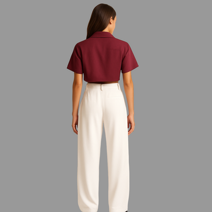 BACK IMAGE OF FEMALE MODEL WEARING WHITE COLOUR LOOSE STRAIGHT FIT WIDE LEGS TROUSER WITH BELT LOOPS AND ONE CUT POCKET AT BACK. MODEL IS WEARING WINE COLOUR CROP SHIRT
